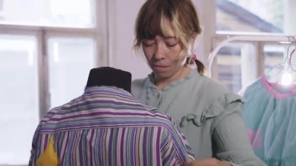 Женщина Дизайнер Примеряет Полосатую Рубашку Манекене Средний Выстрел — стоковое видео