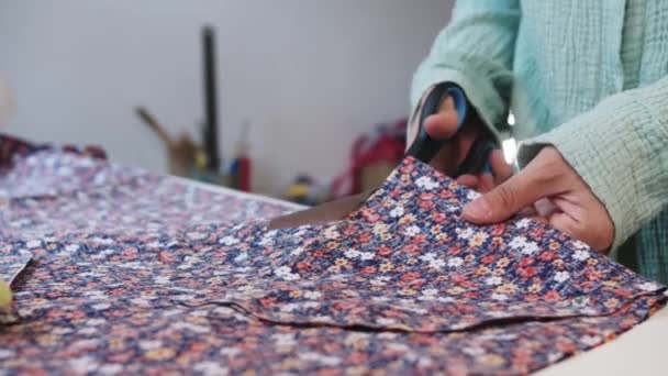 一个女人用剪刀仔细地把花布的花纹剪下来 — 图库视频影像