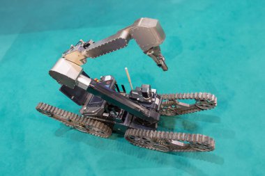 Robot bir kol iş başında, belki bir ürünü monte ediyor ya da test ediyor..