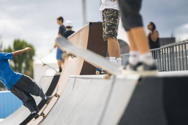 Kaykaycı kaykay rampasından hızla inerken hareketi yakalar..