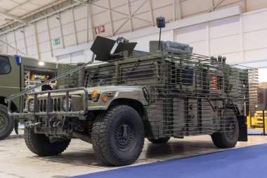 Askerleri veya ekipmanları taşımak için tasarlanmış yeşil renkli bir askeri araç..