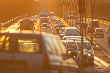 Arabalarla dolu hareketli bir şehir caddesi manzarası, bir şehrin günlük yaşamını resmediyor..