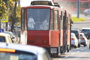 Şehrin bir caddesinde hareket halindeki klasik bir kırmızı tramvay kentteki toplu taşımacılığa şöyle bir göz atıyor:.