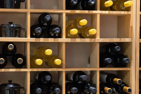 A stack of wine bottles in cabinet shelving in restaurant or cafe