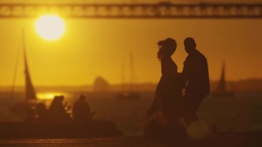 İki figürün ayrıldığı dokunaklı bir sahne. Uzak ufukta güneş batıyor ve köprü oluşuyor..