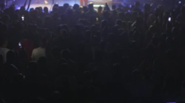 Düşük ışık altında bir konser kalabalığı - dans ve şarkı - rock konseri - yavaş çekim