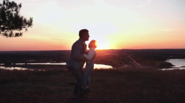 Adam oğluyla oynuyor - gökyüzüne kusuyor - aile gün batımında, manzara arka planda