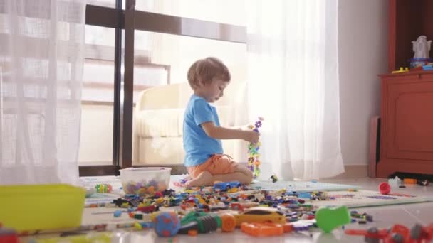 Ένα Μικρό Αγόρι Που Παίζει Παιχνίδια Ένα Δωμάτιο — Αρχείο Βίντεο