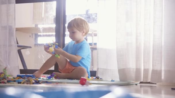 Küçük Bir Çocuk Yerde Oturmuş Oyuncaklarla Oynuyor — Stok video