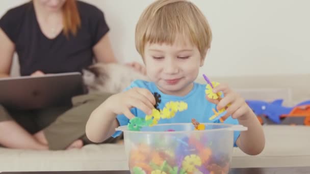 Ein Kleiner Junge Spielt Mit Einem Plastikbecher — Stockvideo
