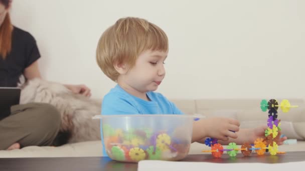 プラスチック製の建物で遊んでいる少年 — ストック動画
