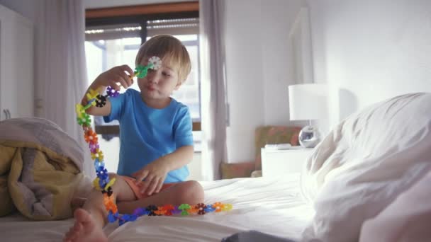 Little Boy Sitting Bed Playing Beads — Stock Video