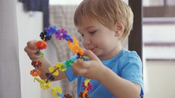 一个小男孩在玩一束塑料花 — 图库视频影像