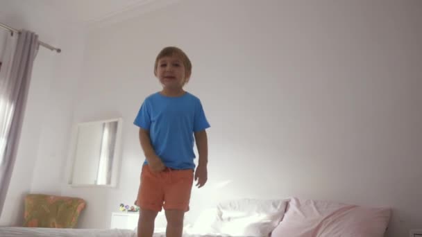 寝室のベッドの上に立っている少年 — ストック動画