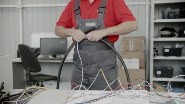 一个穿红衫的人在用电线干活 — 图库视频影像