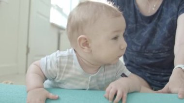 Yoga minderinin yanında gülümseyen bir bebek. Orta çekim