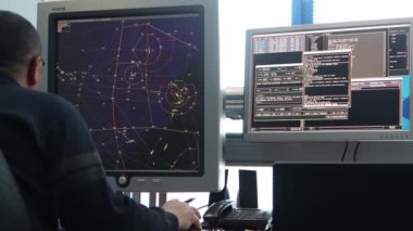 10-02-2021 KAZAN, RUSSIA, Kazan Uluslararası Havalimanı: havaalanındaki seyir odası - haritada yer alan uçuş yolları olan bir monitörle çalışan adam. Orta çekim