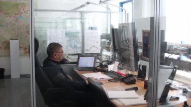 10-02-2021 KAZAN, RUSSIA, Kazan Uluslararası Havalimanı: havaalanındaki navigasyon odası - haritada uçuş yolları olan bir monitörle çalışan yaşlı bir adam. Orta çekim