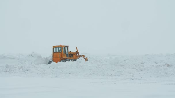 Een Bulldozer Die Door Een Grote Berg Sneeuw Graaft — Stockvideo