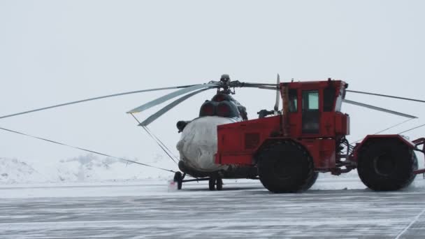 Ελικόπτερο Περιμένει Στο Αεροδρόμιο Tarmac Χιονισμένο Χειμερινή Σκηνή Αεροπλάνα Τηλεφακό — Αρχείο Βίντεο