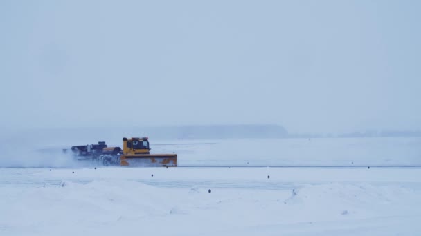 Μεγάλο Κίτρινο Φορτηγό Εκχιονιστικό Αφαιρεί Χιόνι Από Αεροδρόμιο Διάδρομο Χιονόπτωση — Αρχείο Βίντεο
