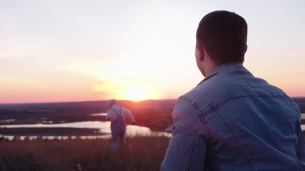 夕日を歩いている父と息子 赤い太陽 — ストック動画