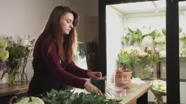 一个女人站在桌子前 手里拿着花 — 图库视频影像