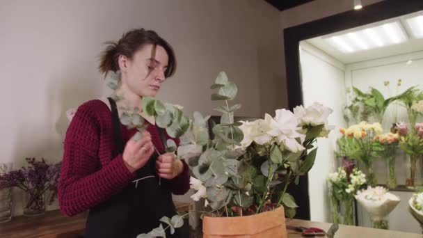 Een Vrouw Die Voor Een Vaas Met Bloemen Staat — Stockvideo