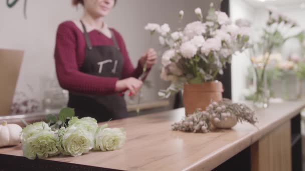 一个女人站在柜台前 手里拿着花 — 图库视频影像