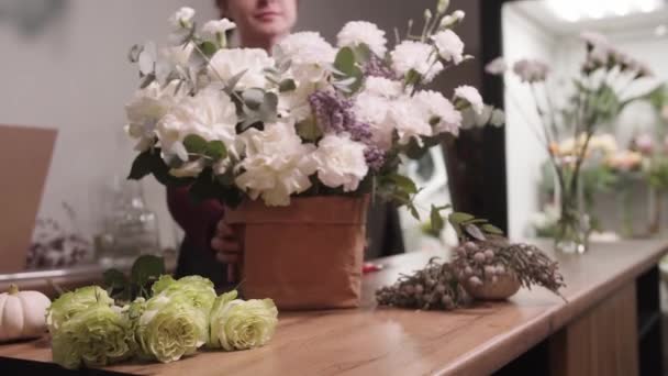 Uma Mulher Frente Balcão Com Flores — Vídeo de Stock