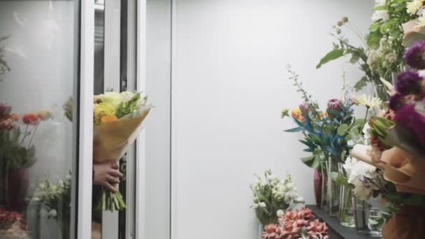 Kobieta Trzymająca Bukiet Kwiatów Przed Oknem — Wideo stockowe