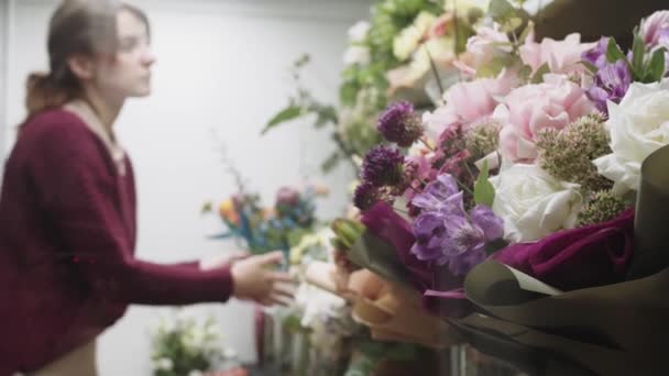 Kobieta Stojąca Obok Bukietu Kwiatów — Wideo stockowe
