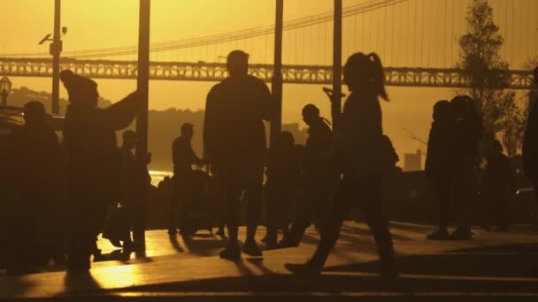 Μια Ομάδα Ανθρώπων Που Διασχίζουν Μια Γέφυρα Χρυσό Ηλιοβασίλεμα — Αρχείο Βίντεο