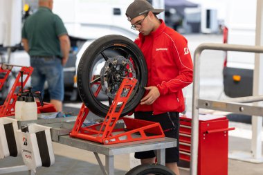 6 Mayıs 2023, Estoril, Portekiz - MotoGP yarışı - Garajda motosiklet lastiği üzerinde çalışan bir adam