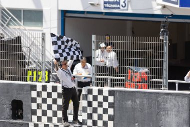 6 Mayıs 2023, Estoril, Portekiz - MotoGP yarışı - Kareli şemsiye tutan bir adam yarış pistinin tepesinde duruyor
