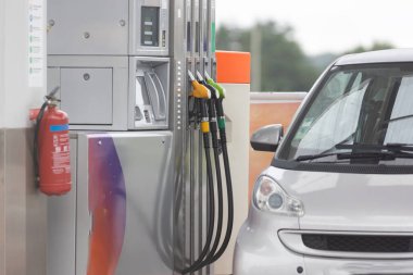 Benzin istasyonunun yanına bir araba park edilmiş.