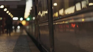 Platformun yanında mırıldanan bir tren ve insanlar...