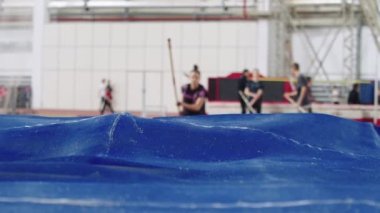Kadın sporcu koşuyor ve Kızıl Trambolinde sırıkla atlama yapıyor - telefoto