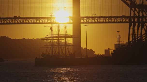 太陽は川の上に大きな橋の後ろに設定されています — ストック動画