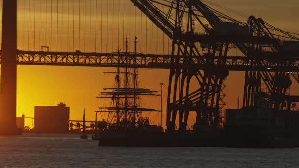 Die Sonne Geht Hinter Einer Großen Brücke Vor Dem Segelschiff — Stockvideo