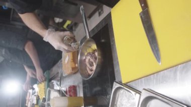 Restoran mutfağı - şef tavadaki deniz ürünleri ahtapotuna sos ekle