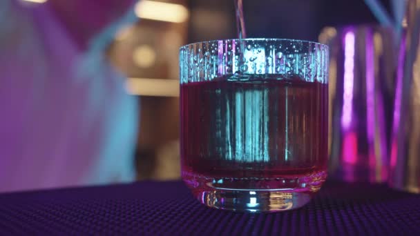 茶几上的一杯液体 在霓虹灯中倒入酒精 — 图库视频影像