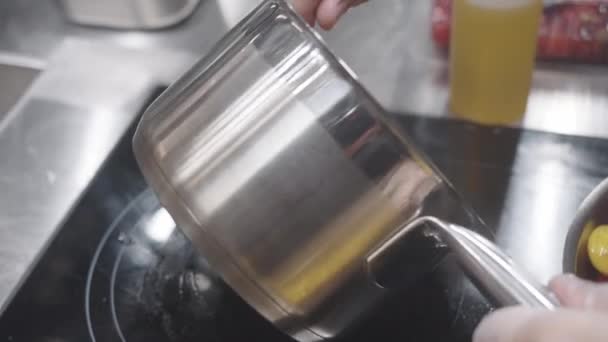 사람은 스토브에 배치된 냄비에 액체를 레스토랑 환경에서 요리를 준비하는 보여줍니다 — 비디오