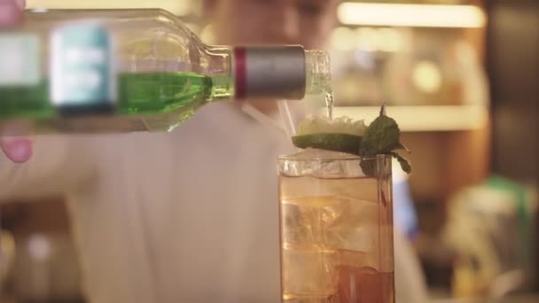 酒保在酒吧间里准备酒精鸡尾酒 在玻璃杯酒吧台或酒吧间里加绿酒 — 图库视频影像