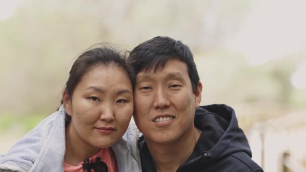 一个亚洲男人和女人在镜头前笑着 男人穿着黑色夹克 女人穿着蓝色夹克 — 图库视频影像