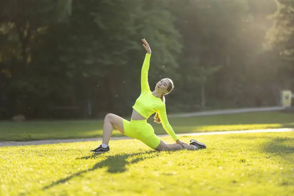 Kvinna Neongrön Outfit Gör Yogapose Ett Gräsplan Ljusa Färgerna Hennes — Stockfoto