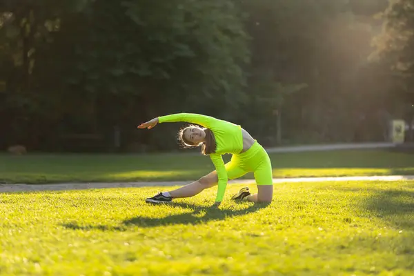 Een Vrouw Een Neon Groene Outfit Doet Een Yoga Pose — Stockfoto