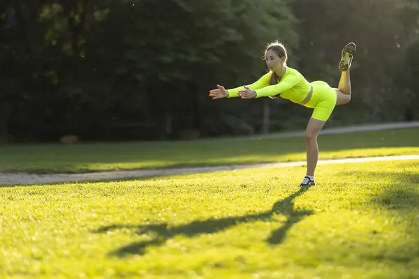 Een Vrouw Een Neon Gele Outfit Doet Een Yoga Pose — Stockfoto