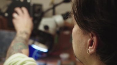 Sakallı ve küpeli bir adam bilgisayar ekranına bakıyor. Odaklanma ve konsantrasyon kavramı. Adam dikkatlice ekrana bakıyor.