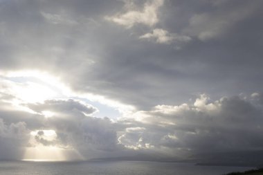 Gökyüzü bulutlu ve güneş bulutların arasında parlıyor, geniş açılı.